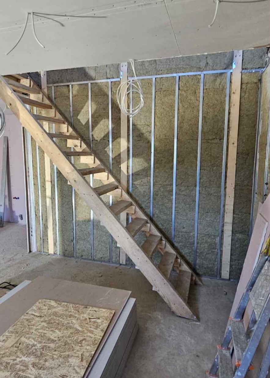 Timber staircase and metal stud walls with insulation mid-renovation