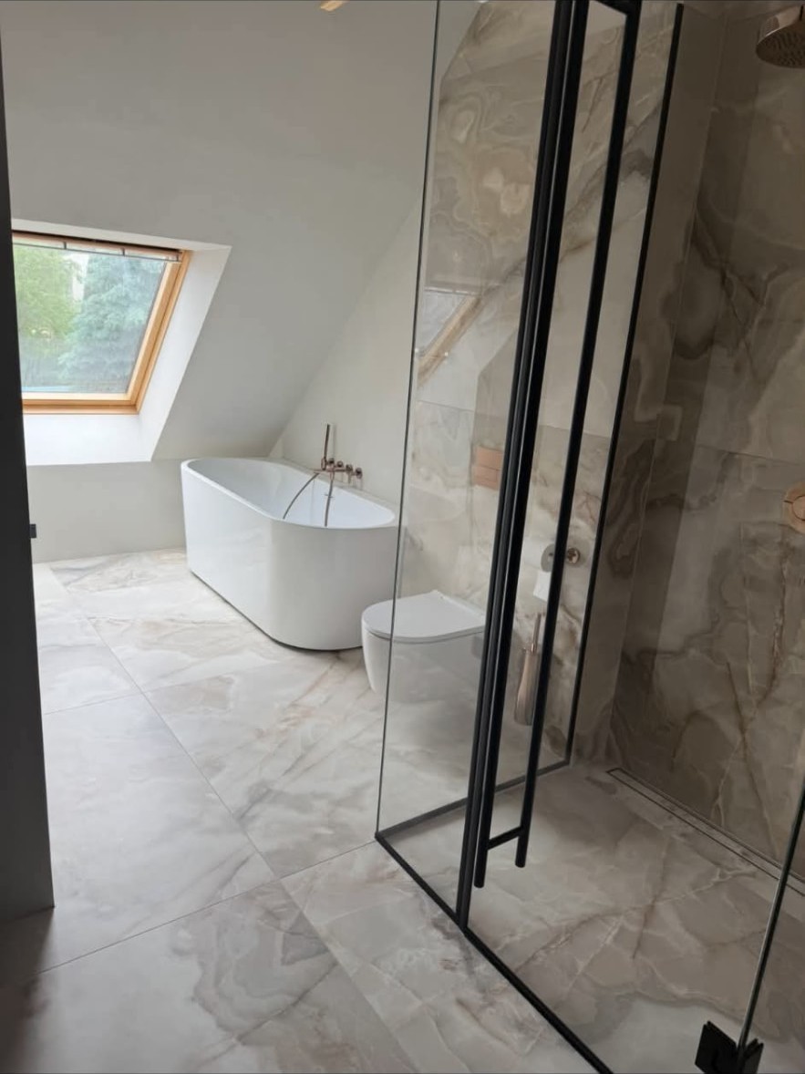 Finished bathroom with freestanding bath and marble-effect tiles