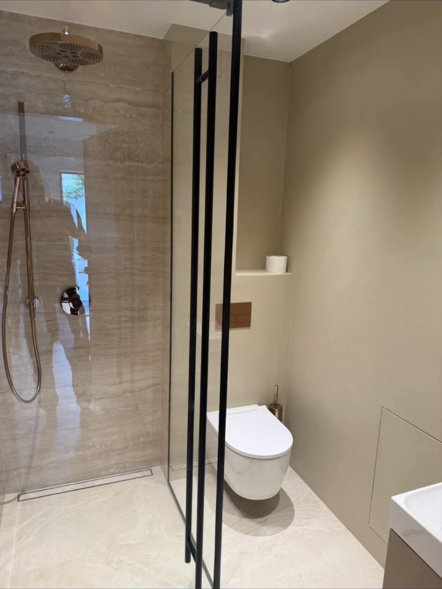 Finished walk-in shower with brass fittings and floating toilet