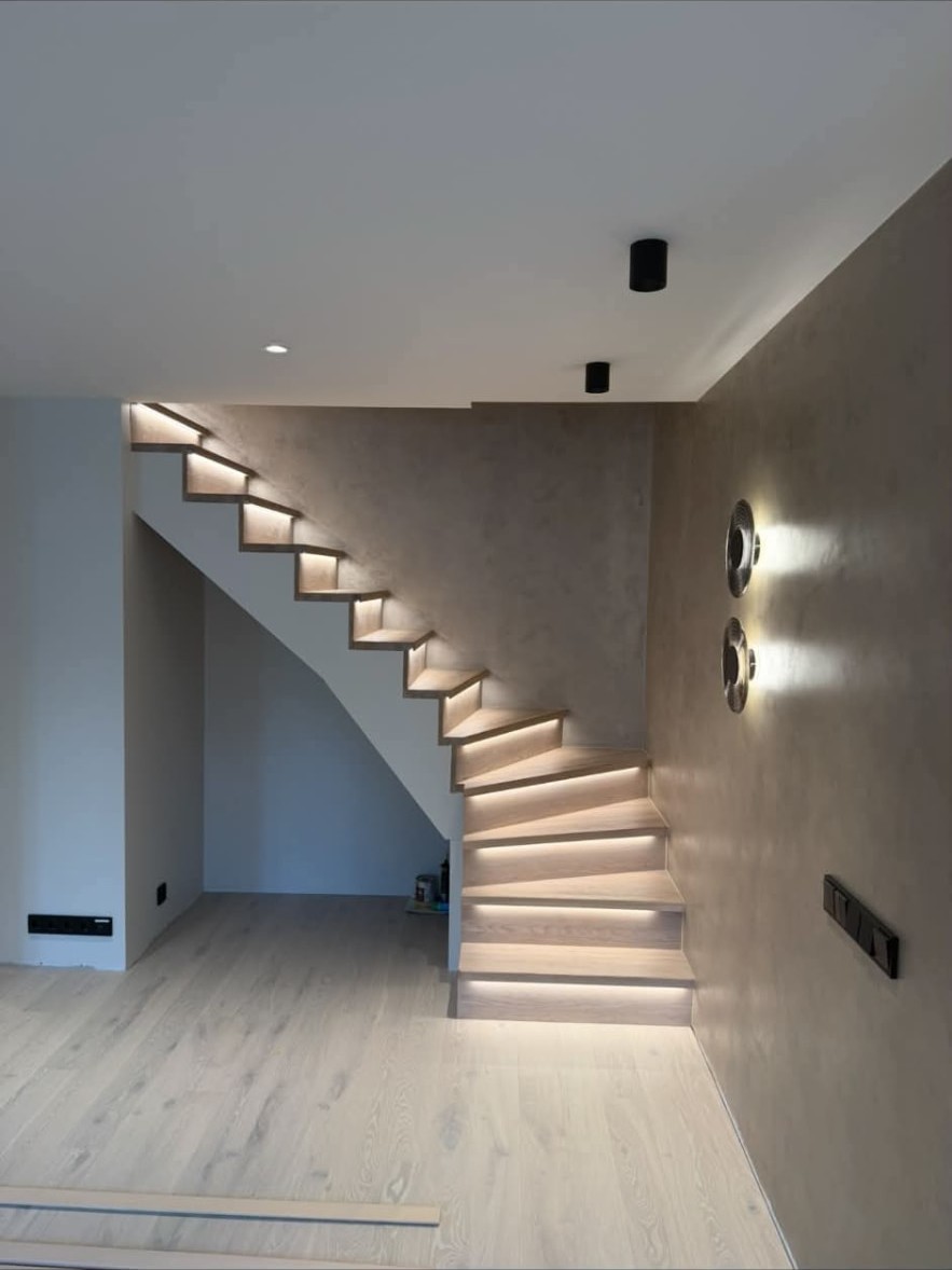 Finished staircase with soft under-step lighting and plastered walls